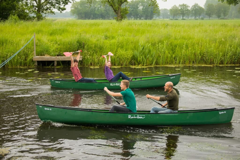 Vier mensen strijden tegen elkaar in duo's in kano's om wie het snelst is.