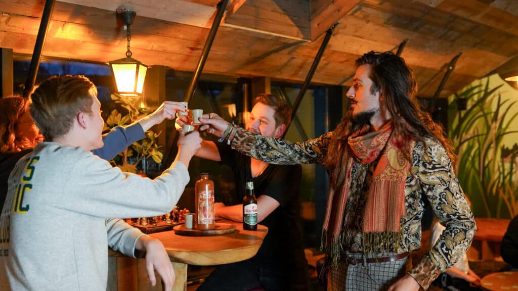 Viertal mensen proosten met een glaasje Taribitter, een kruiden bittertje van Taribush